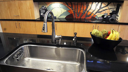 A center island in the Rushing's renovated kitchen holds an extra-deep apron farmhouse sink. The counters are crafted of Absolute Black granite.