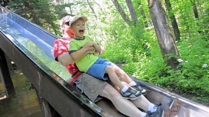 Bryan McCarthy of North Huntingdon holds his son, Michael, 4, as they cruise down the giant slide at Mammoth Park in Mount Pleasant Township, Westmoreland County.
