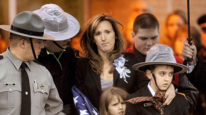 Carrie Cornell, widow of Pennsylvania State Trooper Paul. G. Richey, and her children Conner, 9, and Catherine, 6, leave yesterday's funeral at Franklin Area High School.