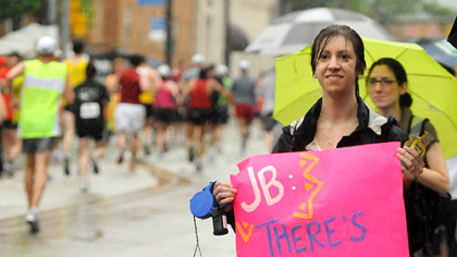 Ashlyn Heider, with her dogs Archie, left, and Lily, watches for her friend Jessica Blasik to pass by during along rainy East Carson Street on the South Side.