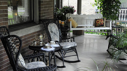 The front porch is large enough for furniture, including a swing.