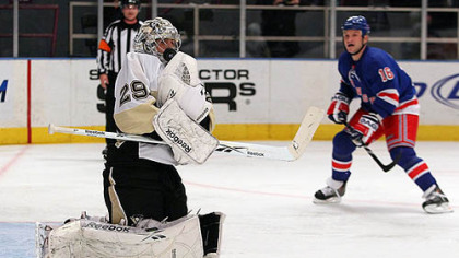 Penguins goaltender Marc-Andre Fleury makes a glove save against as Rangers forward Sean Avery moves in.