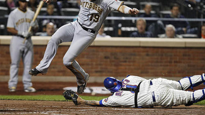 The Pirates' Chris Snyder leaps to avoid being tagged out at the plate by Mets catcher Henry Blanco on an RBI single by Andrew McCutchen during the fourth inning. Snyder missed the plate in his leap and was forced to dive back, but Blanco dropped the ball on the play, allowing the run to score.