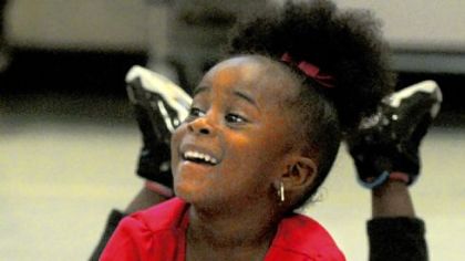 DaNyah Henderson, 3, laughs as she raises her feet.