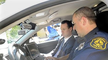 Pittsburgh police Officer Don Adamsky shows new technology features in his cruiser to Mayor Luke Ravenstahl on Tuesday in East Liberty. The new features include wireless laptops and small printers that produce waterproof citations.