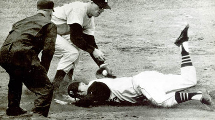 Don Hoak slides into second in the fourth inning of the second World Series game against the New York Yankees. Trying to put the ball on him is Tony Kubek, with Umpire Nestor Chylak calling the play.