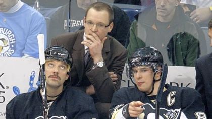 Penguins coach Dan Bylsma, center, listens as Sidney Crosby, right, talks on the bench with teammate Bill Guerin during the first period of a game against Detroit in January.
