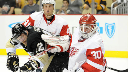 Penguins forward Brett Sterling is stopped by Red Wings goaltender Chris Osgood at Red Wings forward Ilari Filppula defends in the first period of Tuesday's game at Consol Energy Center.