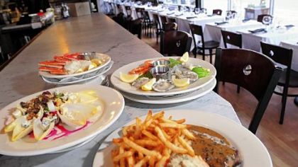 Among selections at Brasserie 33 are beet and endive salad, left, plateau de fruits de mer, and steak frites, right.