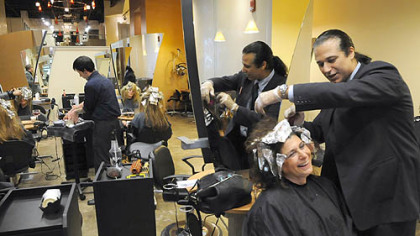 Emilio Cornacchione, right, proprietor of Izzazu salon, works on client Denis Robinson's hair in the salon's new digs next to the Capital Grill on Fifth Ave.