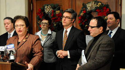 Flanked by Pittsburgh Controller Michael Lamb, left, and other council members, Pittsburgh City Council President Darlene Harris announces a plan that will avoid a state takeover of Pittsburgh's pension plan.