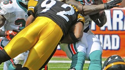 Steelers linebacker James Harrison puts his shoulder into Dolphins running back Ricky Williams in the fourth quarter Sunday at Sun Life Stadium in Miami.
