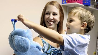 Megan Naughton of Ross holds her son, Duncan, 3, as he interacts with Popchilla, a robot at the Autism Center of Pittsburgh in McCandless. The robot is used to help children with autism with limited or no verbal skills.
