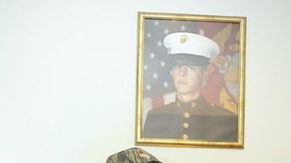 Derrick Earley sits under a 6-year-old portrait of himself as a 17-year-old Marine recruit at Parris Island, S.C.