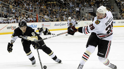 Blackhawks left wing Bryan Bickell  takes a shot as Penguins defenseman Ben Lovejoy pressures during the first period.