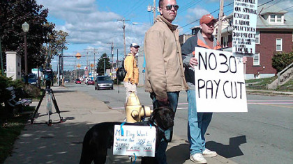 Medics picket outside of the Munhall Borough building as area mayors, ambulance service management and union leaders met today. The sign on one medic's dog reads, "My dog won't work for 30% less! Strike for fair pay."