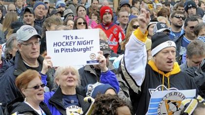 Patti Koerbel from Gibsonia (with sign) and Dan Zadach from Jefferson Hills (full Pens garb) were among the fans who thronged Market Square for the Penguins rally Thursday ahead of the Winter Classic against the Washington Capitals on Saturday.