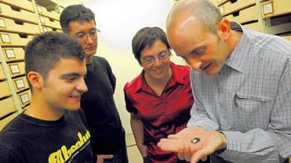 Paleontologists from the Centre National de la Recherche Scientifique in Montpellier, France, from left, Anthony Ravel, Rodolphe Tabuce, Anusha Ramdarshan and Laurent Marivaux, take a closer look at a 50-million-year-old Shoshonius cooperi primate skull fossil from Wyoming on Thursday at the Carnegie Museum of Natural History in Oakland. Scientists from 31 countries are attending the annual meeting of the Society of Vertebrate Paleontologists starting today at the David L. Lawrence Convention Center.
