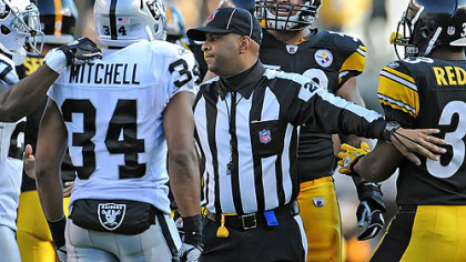 Line judge Adrian Hill has to separate Maurkice Pouncey and Mike Mitchell of the Raiders Sunday at Heinz Field.