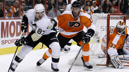 Penguins captain Sidney Crosby works the puck against Flyers forward Jeff Carter as goaltender Brian Boucher looks on in the first period of an Tuesday's game at Wells Fargo Center in Philadelphia.
