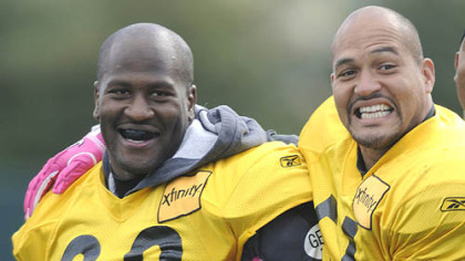 Steelers linebacker James Farrior tries to get linebacker James Harrison to smile at the cameras photographing the team's drills at practice Thursday.