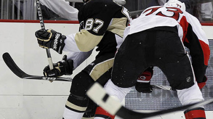 Penguins captain Sidney Crosby is defended by Senators forward Jarkko Ruutu in the second period.