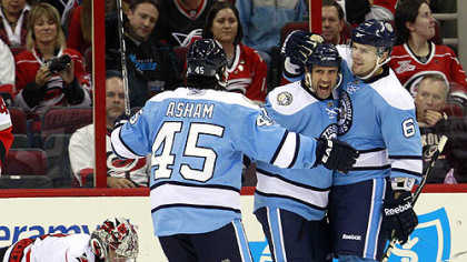 Penguins forward Arron Asham and defenseman Ben Lovejoy, right, celebrate with forward Max Talbot after Talbot scored a on Hurricanes goalie Cam Ward during the second period of game at RBC Center in Raleigh, N.C., Saturday.