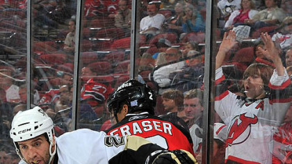 Devils defenseman Mark Fraser is checked by Penguins forward Maxime Talbot #25 during the third period.