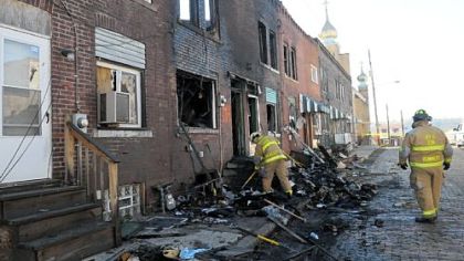 Firefighters work at the scene of a Wednesday fire in a set of row houses on Mound Street in Rankin, which left 11 people homeless.