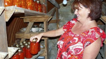 Shelba Fullmer, of Arthurdale, W.Va., with some of the hot peppers and tomato sauce  she canned this summer.