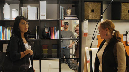 Chef David Racicot,reflected in the mirror, listens to designer Jen Bee, right, as they start off their tour of Ikea.