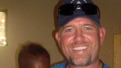 Sean Casey holds a baby with AIDs.