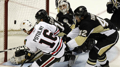 Blackhawks forward Ryan Potulny can''t get a shot by Penguins goaltender Brent Johnson in the first period as as Penguisn forward Mike Comrie and Eric Tangradi defend.