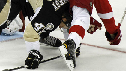 Red Wings defenseman Brad Stuart collides with Penguins forward Tyler Kennedy during the first period.