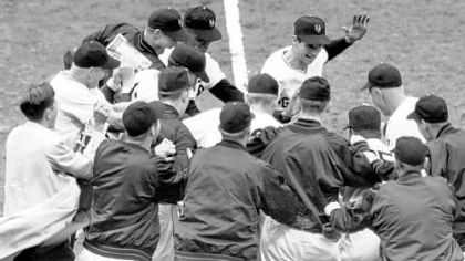 This Oct. 3, 1951, file photo shows the New York Giants baseball team greeting teammate Bobby Thomson, center rear with hand raised, after Thomson's ninth-inning homerun against the Brooklyn Dodgers, to give his team a 5-4 victory and a trip to the World Series, at the Polo Grounds in New York.