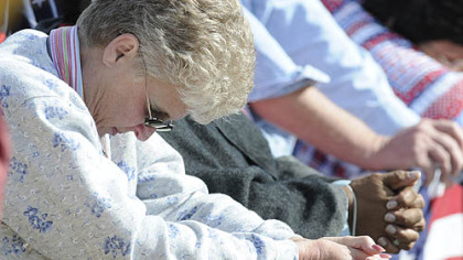 A women bows during the invocation prayer at the Flight 93 National Memorial today in Shanksville.