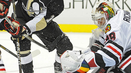 Penguins forward Mike Comrie battles for a loose puck in front of Blackhawks goaltender Alec Richards during Tuesday's game at Consol Energy Center.