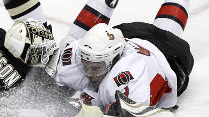 Senators forward Milan Michalek slides into Penguins goaltender Brent Johnson in the first period.