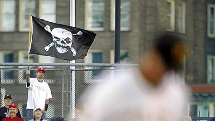 A fan supports the Pirates in the outfield bleachers as pitcher Paul Maholm warms up in the foreground Saturday.