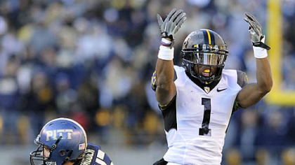 West Virginia's Tavon Austin waves his hands behind Pitt's Max Gruder a run in the third quarter at Heinz Field Friday.