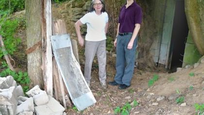 Kathleen Sullivan and Greg Galford stand in front of the root cellar entrance at Eden Hall Farm.