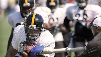 To help drive home the point of hanging onto the ball, coaches use boxing gloves at the end of poles during drills with the running backs Tuesday at Saint Vincent College. The Steelers fumbled twice in their preseason opener.