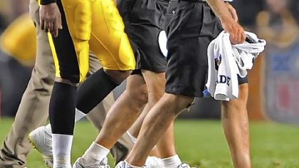 Byron Leftwich leaves the field with the medical staff after his left knee was injured in the second quarter Thursday night at Heinz Field.