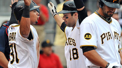Neil Walker (18) is greeted at home plate by Jose Tabata, left, after his two-run home run in the sixth inning Monday at PNC Park. Garrett Jones, right, was up next.