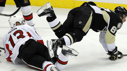 Penguins captain Sidney Crosby collides with Senators forward Peter Regin in the first period.