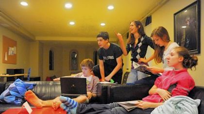 Cameron Clark, left, works on his computer as, from left to right, Seth Klein-Tooley, 13, Alyssa Drake, 16, Erin Young, 17, and Aidan Schubert, 16, watch television in a common room at the Pittsburgh Ballet Theatre's Byham house for out-of-town students.