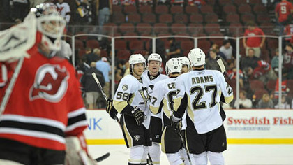 Devils goaltender Martin Brodeur skates back to goal as Penguins defenseman, Paul Martin is congratulated after scoring an empty net goal in the third period by teammates Kris Letang, Chris Kunitz, Sidney Crosby and Craig Adams Monday at the Prudential Center in Newark, N.J.