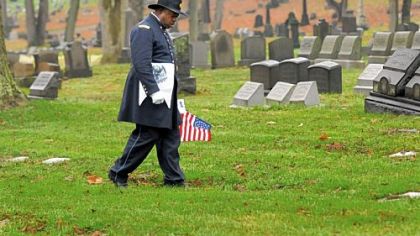 Jeffrey Burton, portraying Major Martin R. Delaney of the 104th USCT (U.S. Colored Troops) and the first black field officer in the Civil War, walks through Allegheny Cemetery in Lawrenceville on Sunday looking for USCT soldiers' graves to honor them with a flag.