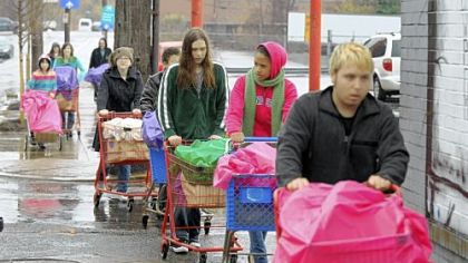 Braving Sunday morning's pouring rain, young people from the Allegheny Unitarian Universalist Church push carts containing 100 bags of groceries to the Northside Common Ministries Food Pantry on Brighton Road.