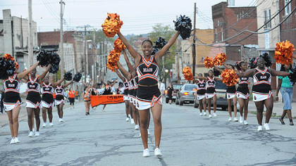 Ashae Berry, 16, leads the Clairton cheerleaders along Miller Avenue to the Clairton stadium before a home game Sept. 24 against Chartiers-Houston.